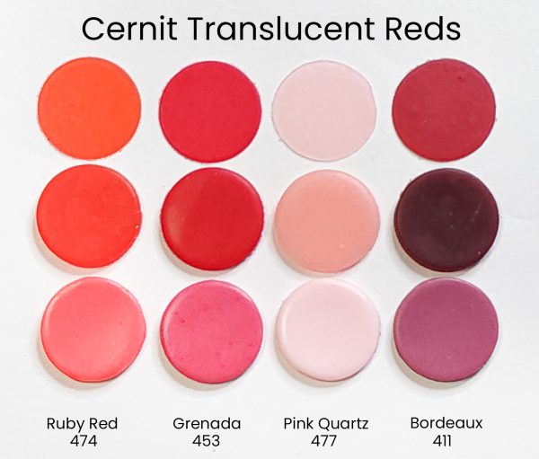 An array of circular swatches of Cernit translucent polymer clay, showing the red and pink colors in their range.