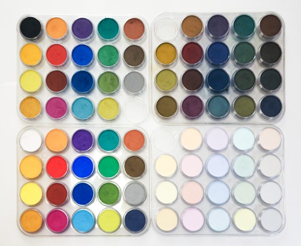Four trays of 20 Pan Pastels, a type of soft pastel, each tray with an array of colors. Each tray contains the pure color, a tint, or a shade.